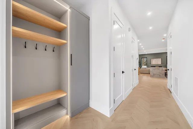 a view of a hallway with wooden floor windows and a bathroom