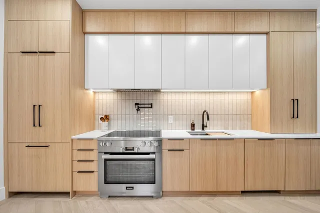 a kitchen with a sink a stove and cabinets