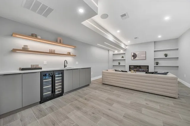 a large white kitchen with kitchen island a sink stainless steel appliances and cabinets