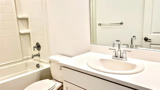 a white toilet sitting next to a bathroom sink