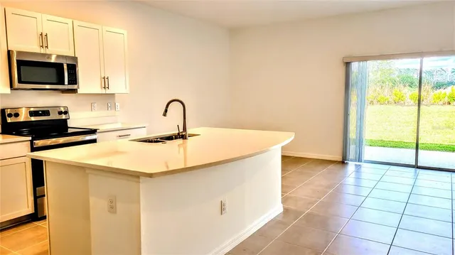a kitchen with a sink a counter top space and stainless steel appliances