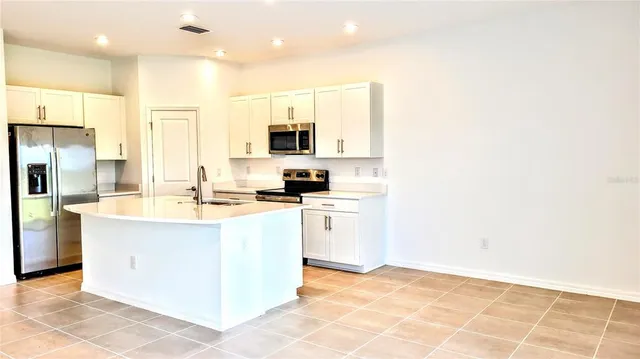 a kitchen with stainless steel appliances granite countertop a sink and a refrigerator