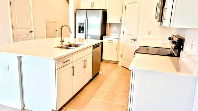 a kitchen with a sink a stove and cabinets