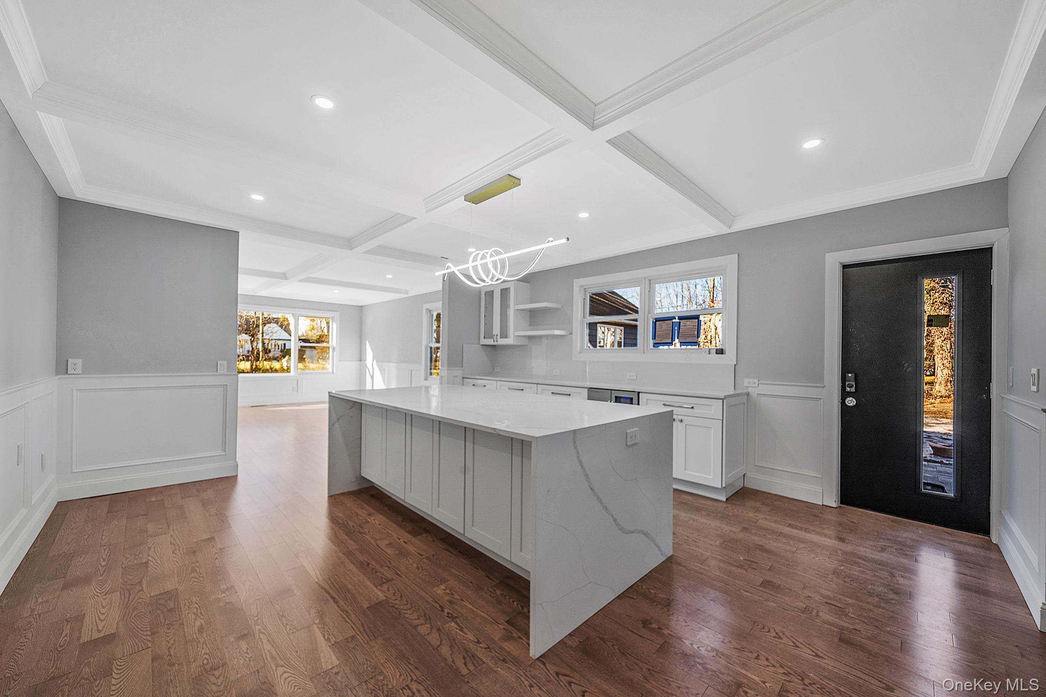 141 Wilmot Road Scarsdale, NY 10583 - Photo 15 of 49 Kitchen with coffered ceiling, white cabinets, wainscoting, a decorative wall, and open shelves