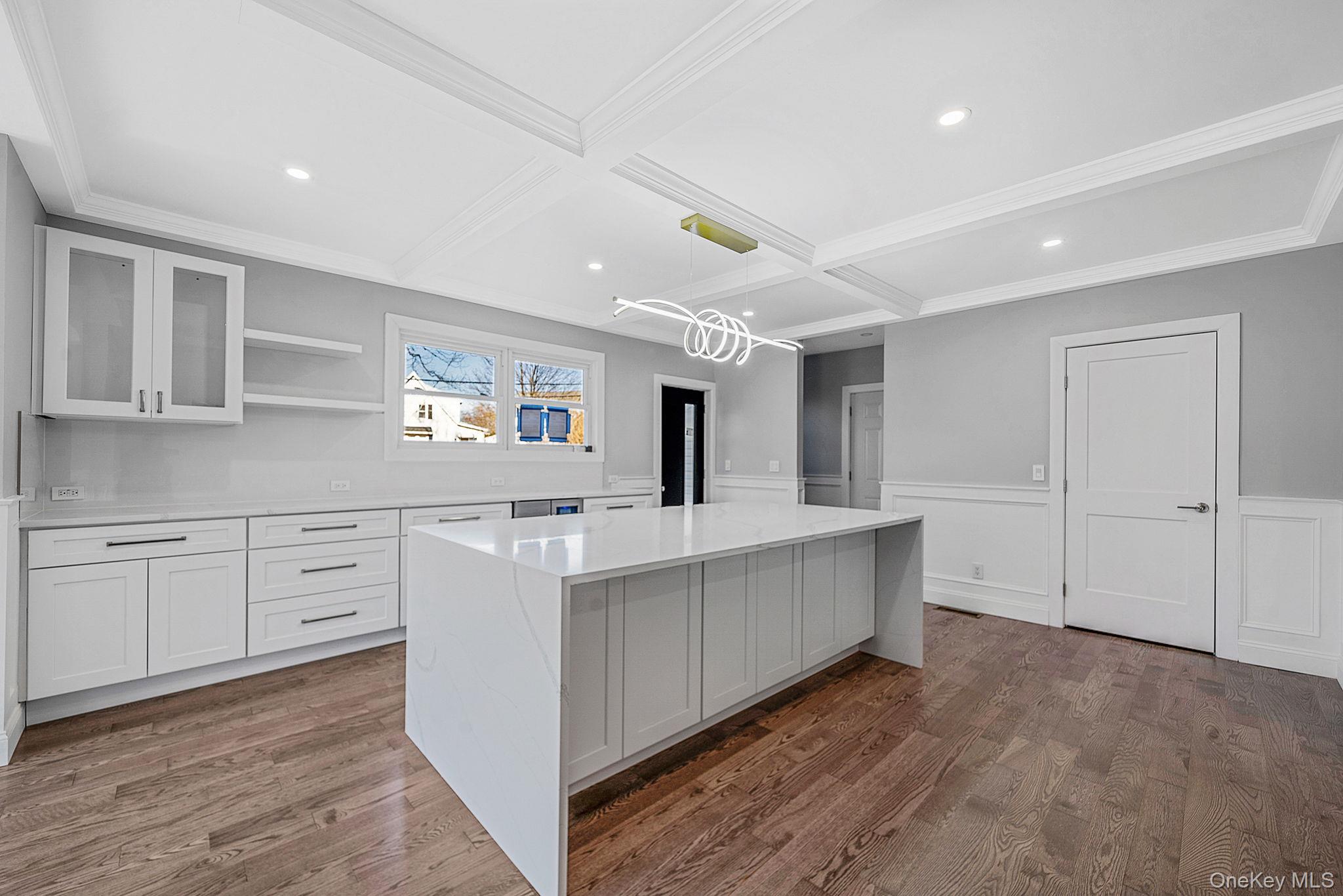 141 Wilmot Road Scarsdale, NY 10583 - Photo 16 of 49 Kitchen with white cabinets, coffered ceiling, pendant lighting, open shelves, and glass insert cabinets