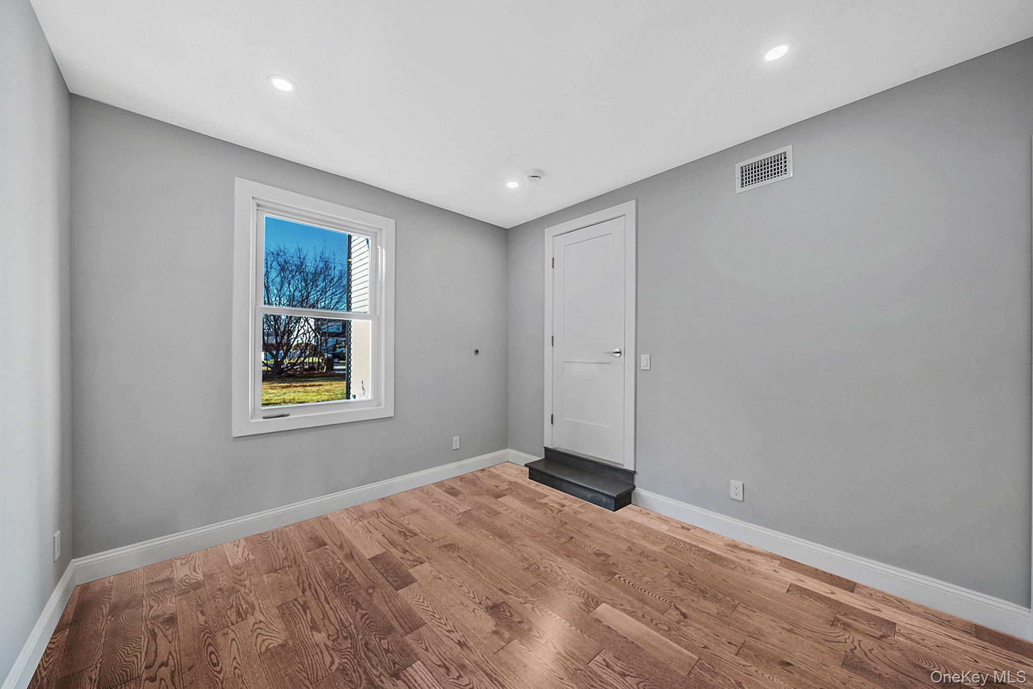 141 Wilmot Road Scarsdale, NY 10583 - Photo 17 of 49 Empty room with wood finished floors and recessed lighting