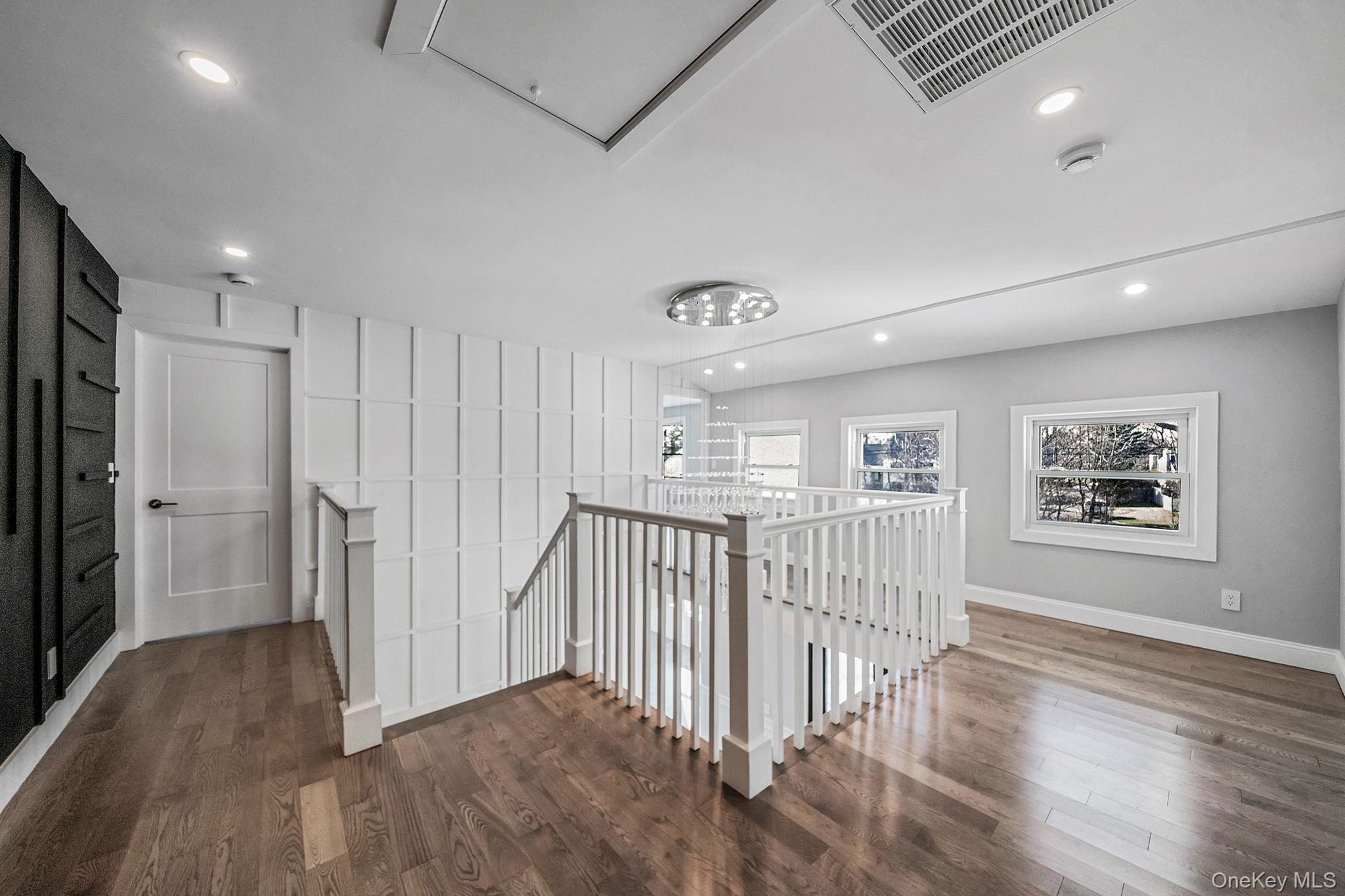 141 Wilmot Road Scarsdale, NY 10583 - Photo 18 of 49 Hallway with an upstairs landing, dark wood finished floors, recessed lighting, and attic access