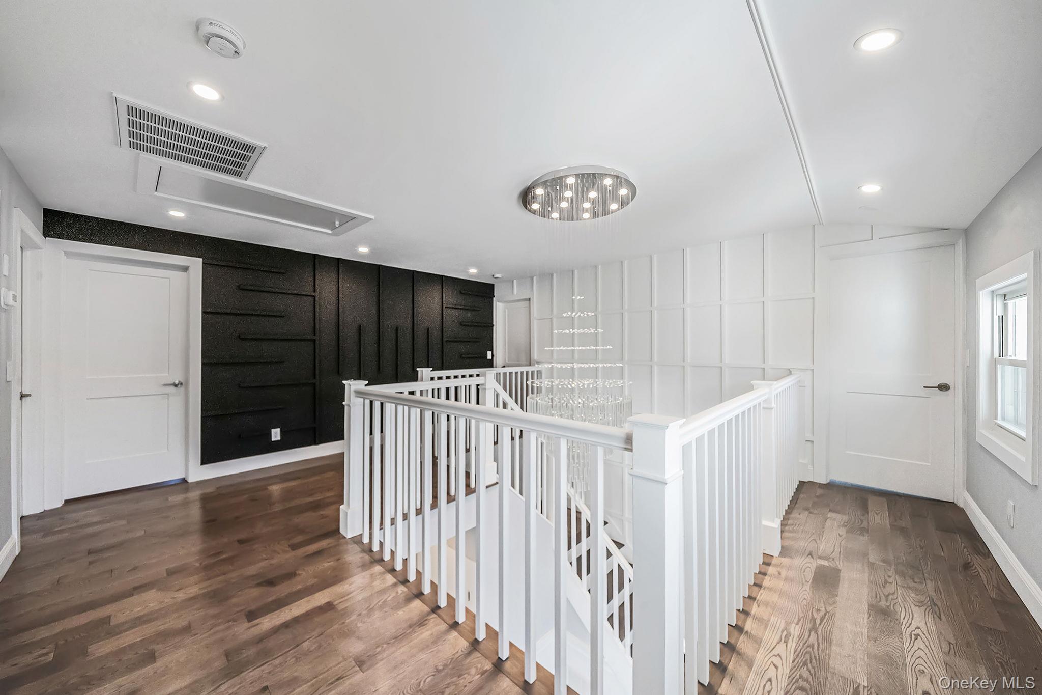 141 Wilmot Road Scarsdale, NY 10583 - Photo 19 of 49 Corridor with an upstairs landing, attic access, dark wood-type flooring, a chandelier, and recessed lighting