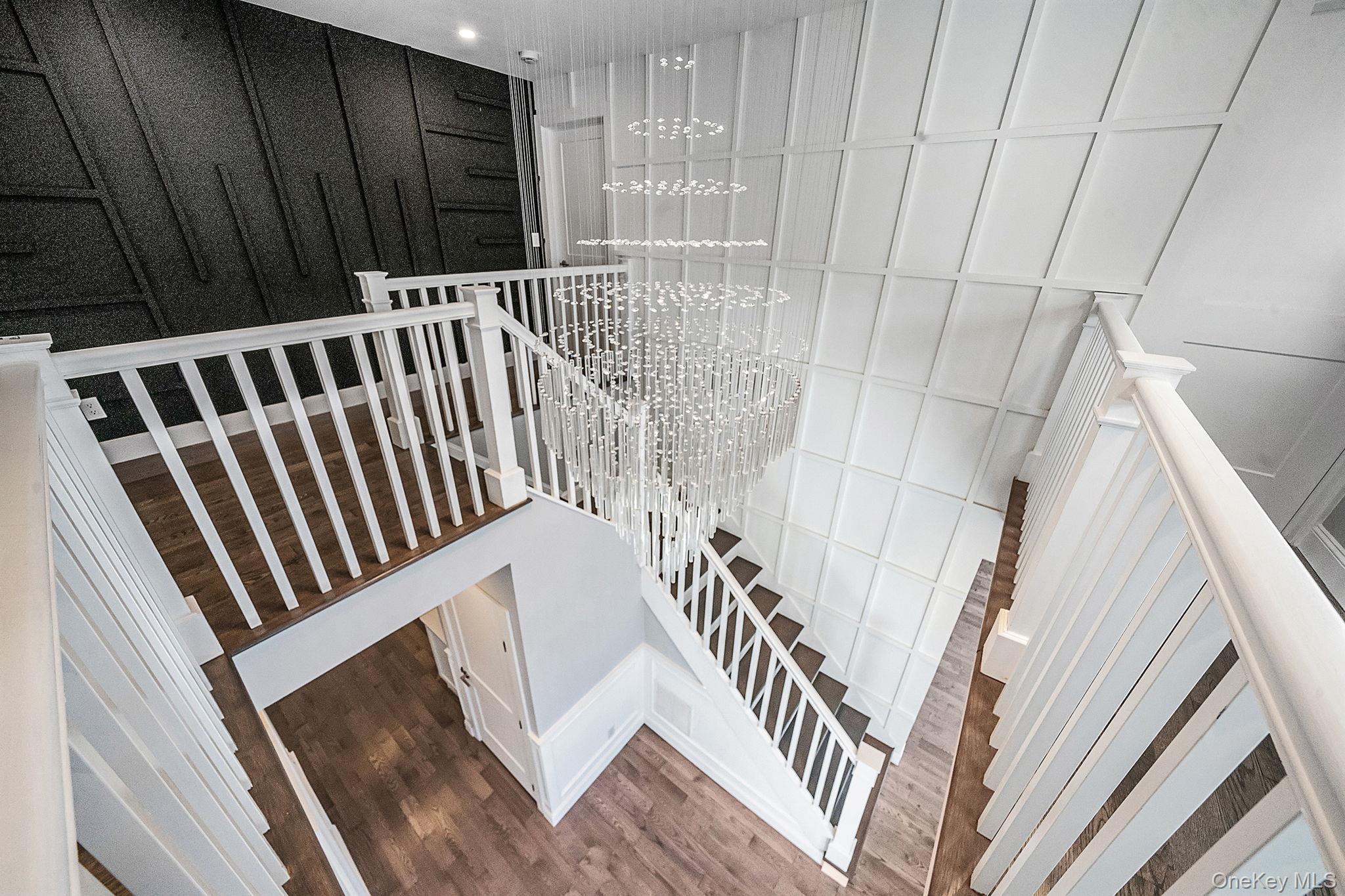141 Wilmot Road Scarsdale, NY 10583 - Photo 20 of 49 Stairway featuring a chandelier and wood finished floors