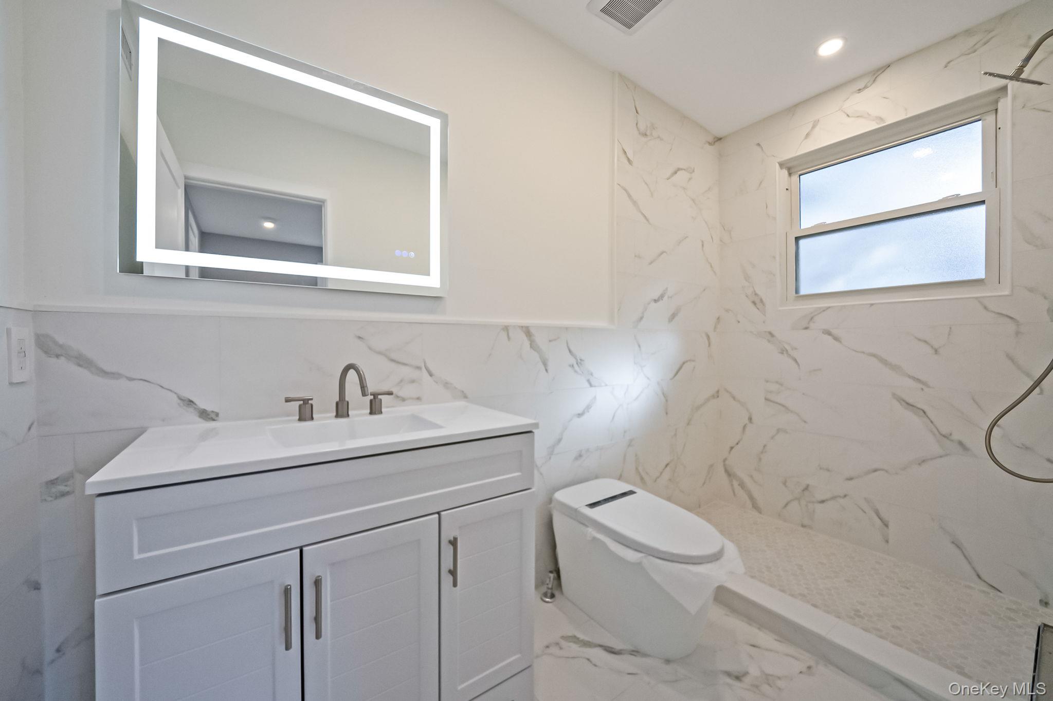 141 Wilmot Road Scarsdale, NY 10583 - Photo 28 of 49 Full bathroom featuring vanity, marble tiled flooring, a marble finish shower, recessed lighting, and tile walls