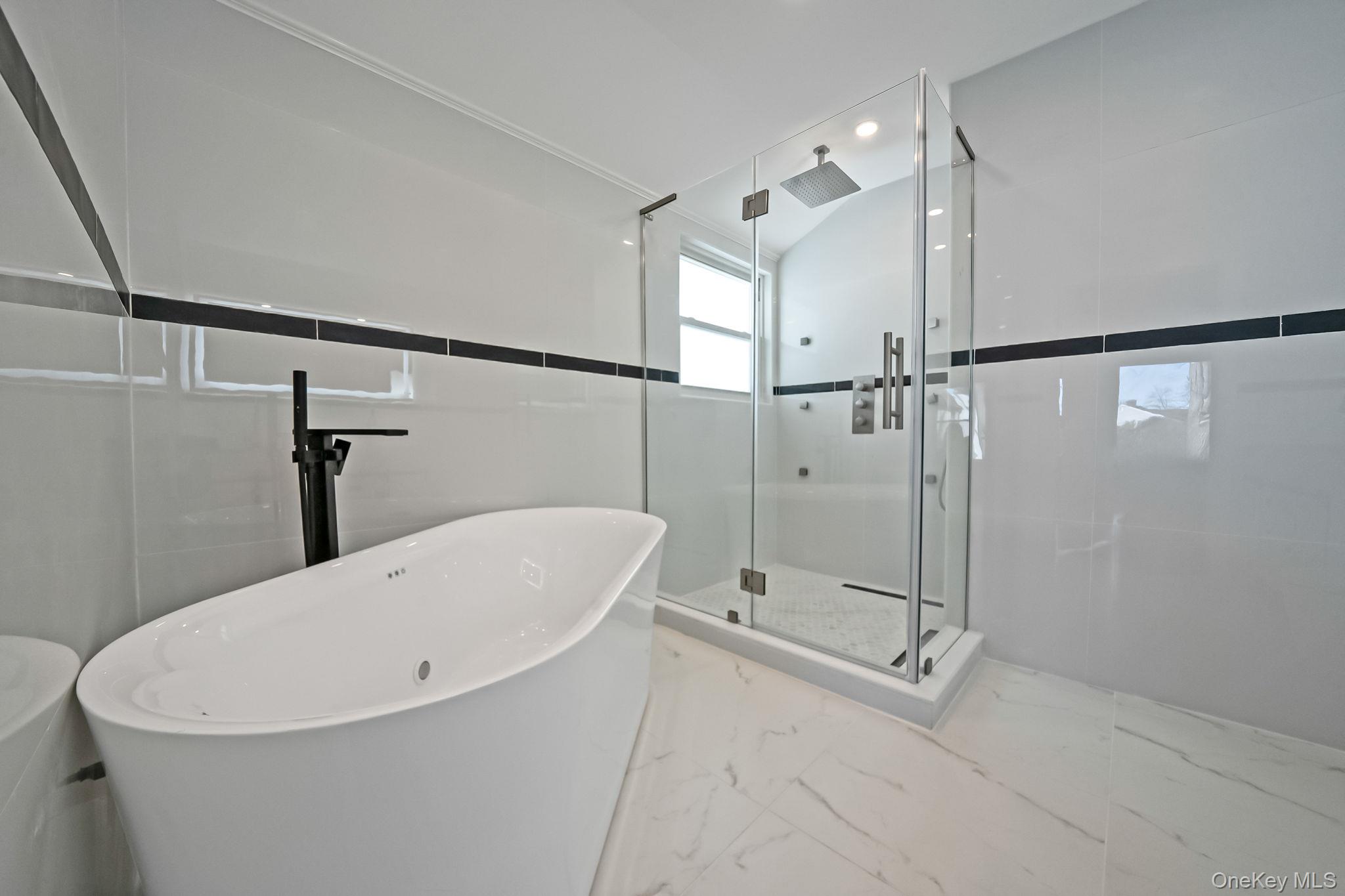 141 Wilmot Road Scarsdale, NY 10583 - Photo 32 of 49 Full bathroom featuring marble tiled floors, a stall shower, and a freestanding tub