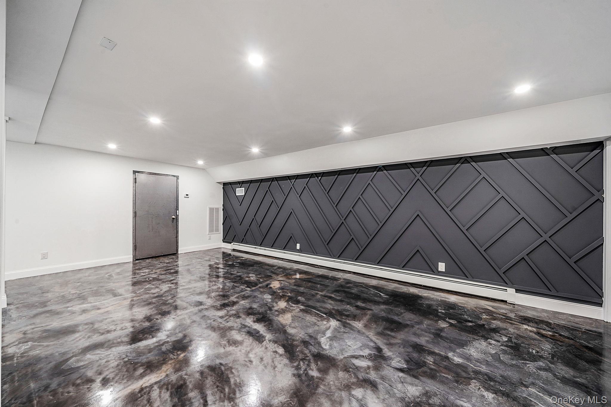 141 Wilmot Road Scarsdale, NY 10583 - Photo 35 of 49 Spare room with recessed lighting, baseboard heating, finished concrete flooring, and a barn door