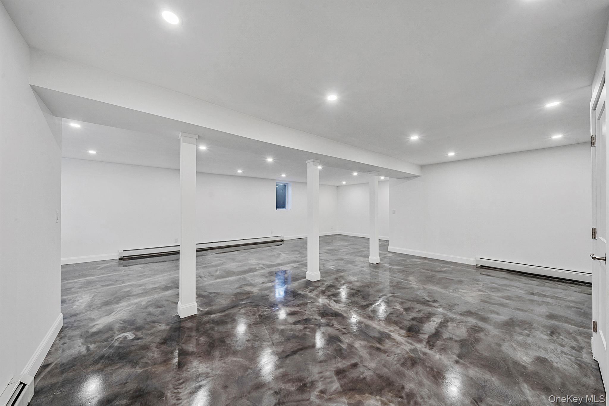 141 Wilmot Road Scarsdale, NY 10583 - Photo 37 of 49 Finished basement featuring a baseboard radiator, recessed lighting, and baseboard heating