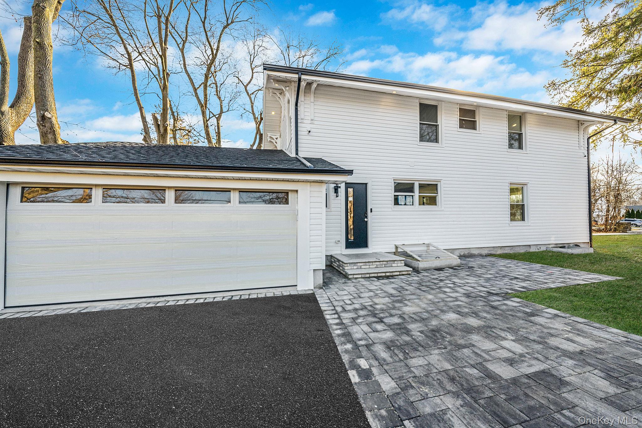 141 Wilmot Road Scarsdale, NY 10583 - Photo 40 of 49 View of front of home with a garage, driveway, and a front yard