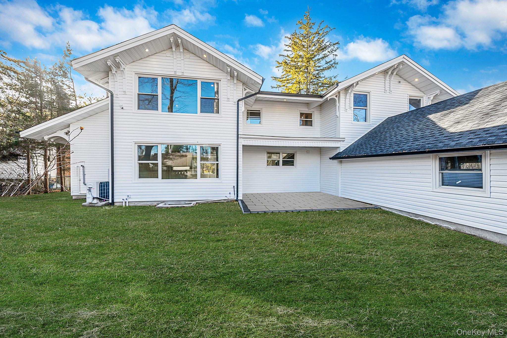 141 Wilmot Road Scarsdale, NY 10583 - Photo 42 of 49 Back of house featuring a patio area and a lawn