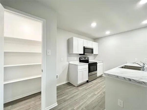 a kitchen with sink a microwave and cabinets