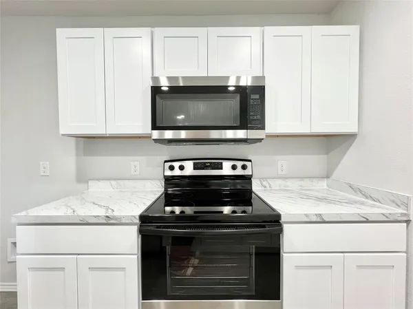 a stove top oven sitting inside of a kitchen
