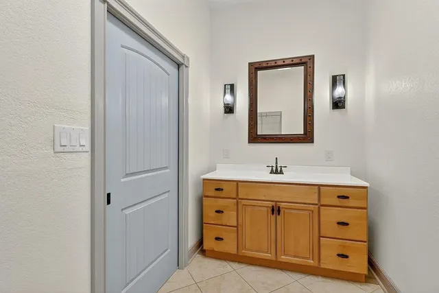 a bathroom with a granite countertop sink vanity and mirror