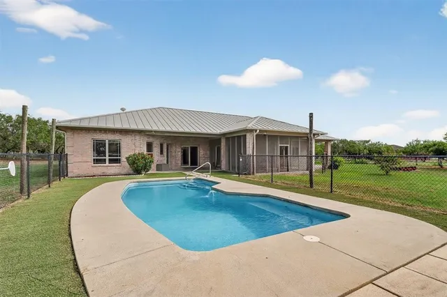 a view of a house with swimming pool and a yard