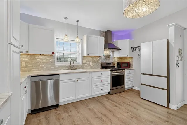 a kitchen with granite countertop a refrigerator stove top oven and sink