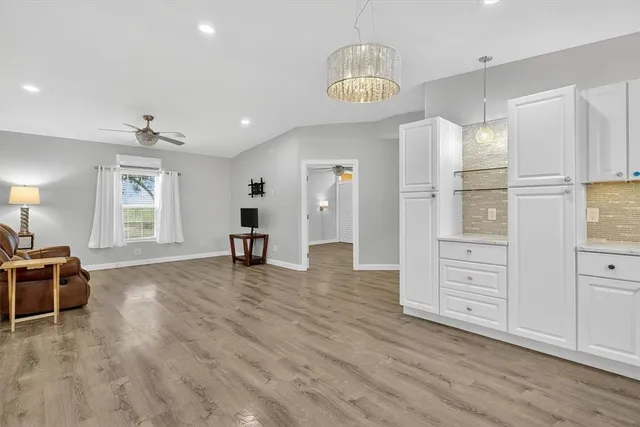 a view of a kitchen with refrigerator and wooden floor