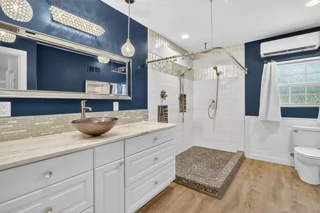 a spacious bathroom with a granite countertop sink mirror vanity and bathtub