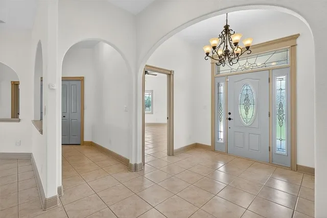 a view of a hallway with wooden floor and chandelier