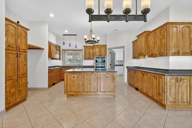 a kitchen with stainless steel appliances granite countertop a refrigerator a stove and a sink