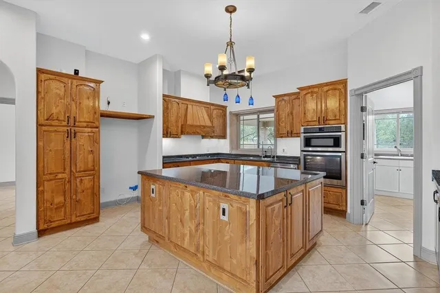 a kitchen with stainless steel appliances granite countertop a refrigerator and a stove top oven