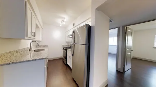 a kitchen with stainless steel appliances granite countertop a refrigerator and a sink