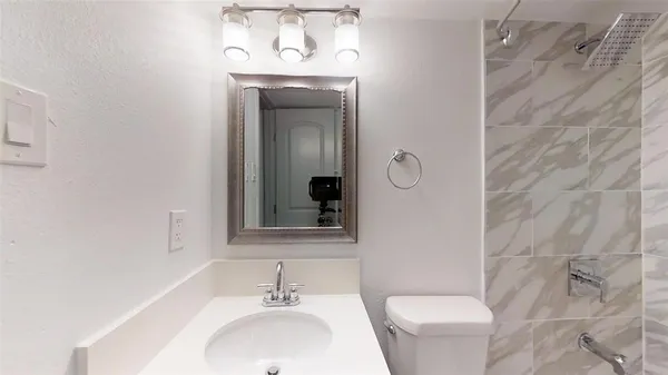 a bathroom with a toilet sink and mirror