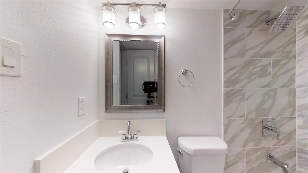404 East 9th Street, Unit 4205 Dallas, TX 75203 - Photo 7 of 12 a bathroom with a toilet sink and mirror