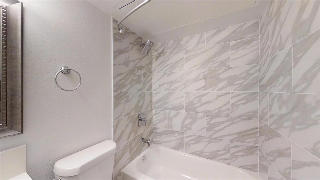 404 East 9th Street, Unit 4205 Dallas, TX 75203 - Photo 8 of 12 a bathroom with a toilet and a shower curtain