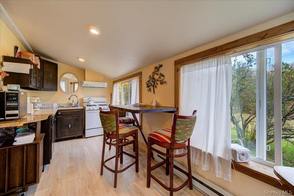 30 Walnut Mountain Road Liberty, NY 12754 - Photo 31 of 48 a kitchen with stainless steel appliances granite countertop a stove top oven a sink dishwasher a dining table and chairs with wooden floor