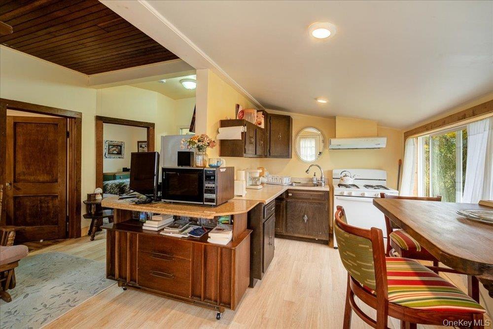 30 Walnut Mountain Road Liberty, NY 12754 - Photo 34 of 48 a open kitchen with stainless steel appliances granite countertop a stove top oven a sink dishwasher a dining table and chairs with wooden floor