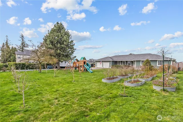 a view of a house with backyard and sitting area