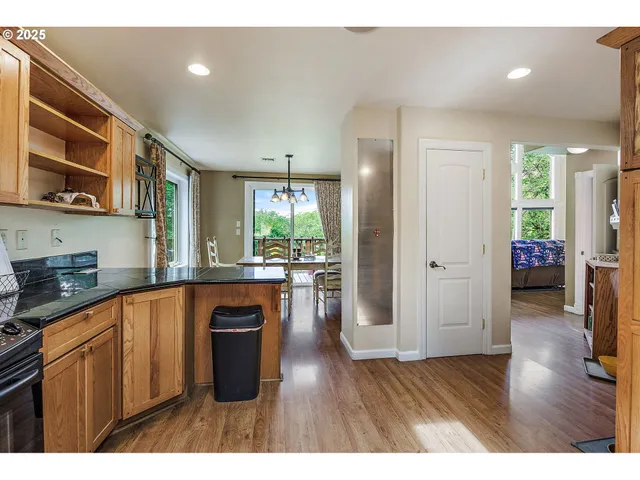 a kitchen with stainless steel appliances granite countertop a stove a sink dishwasher and a refrigerator with wooden floor