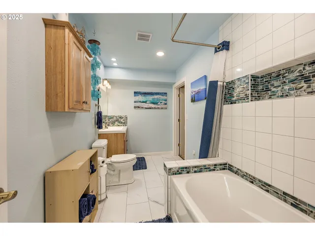 a bathroom with a tub a sink and mirror