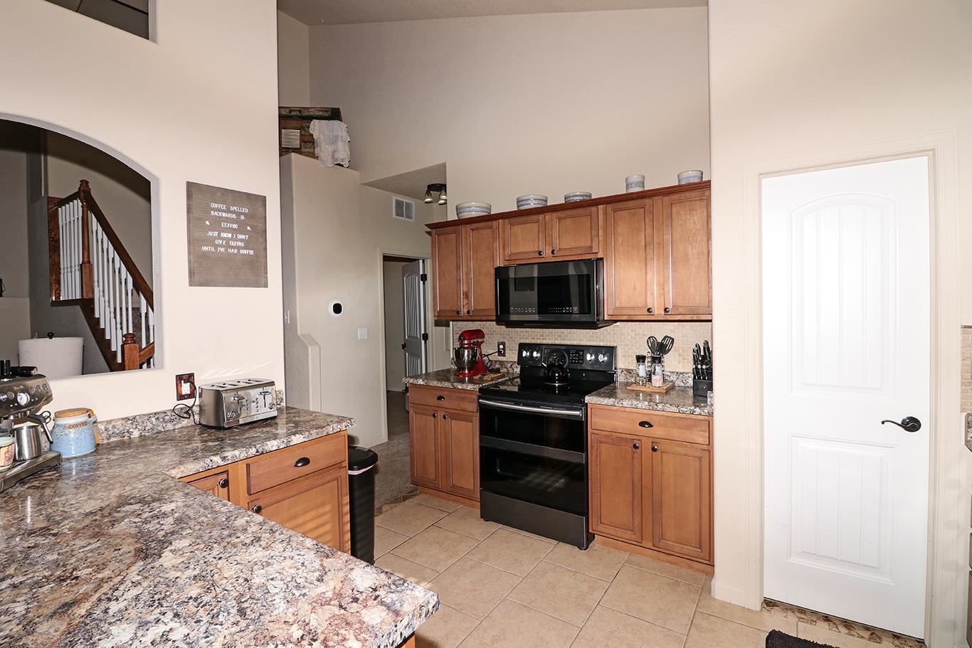 2011 Roma Avenue Fruita, CO 81521 - Photo 10 of 31 a kitchen with stainless steel appliances granite countertop a stove top oven a sink dishwasher and a refrigerator with wooden floor