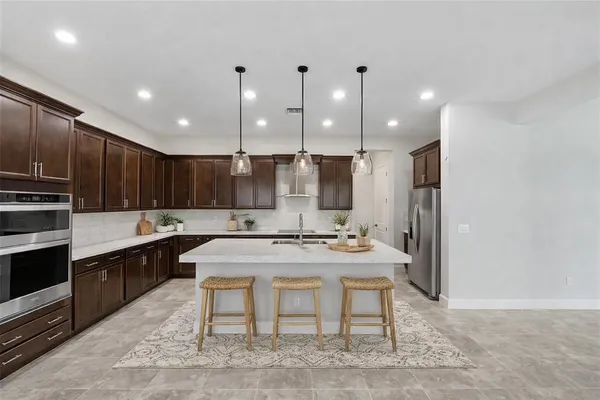 a kitchen with kitchen island stainless steel appliances a sink and cabinets