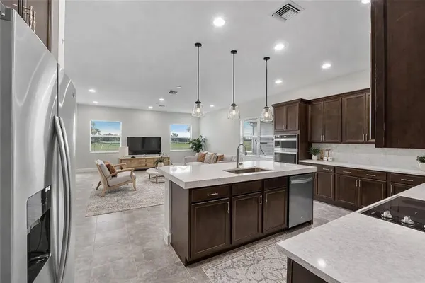 a kitchen with stainless steel appliances granite countertop a sink a stove and a refrigerator