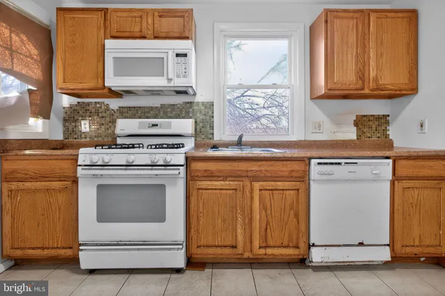 a kitchen with white cabinets and white appliances