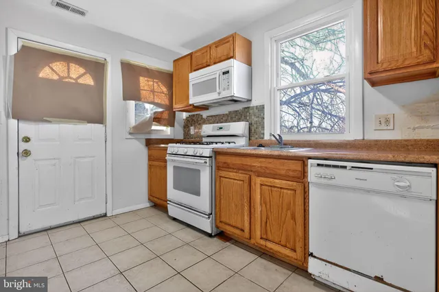 a kitchen with white cabinets and white appliances