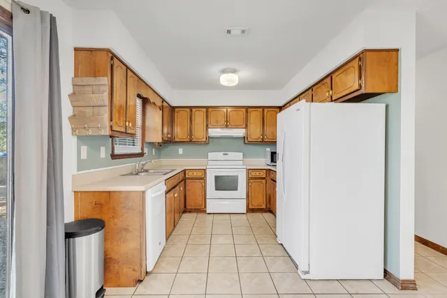 a kitchen with stainless steel appliances granite countertop a refrigerator and a stove top oven