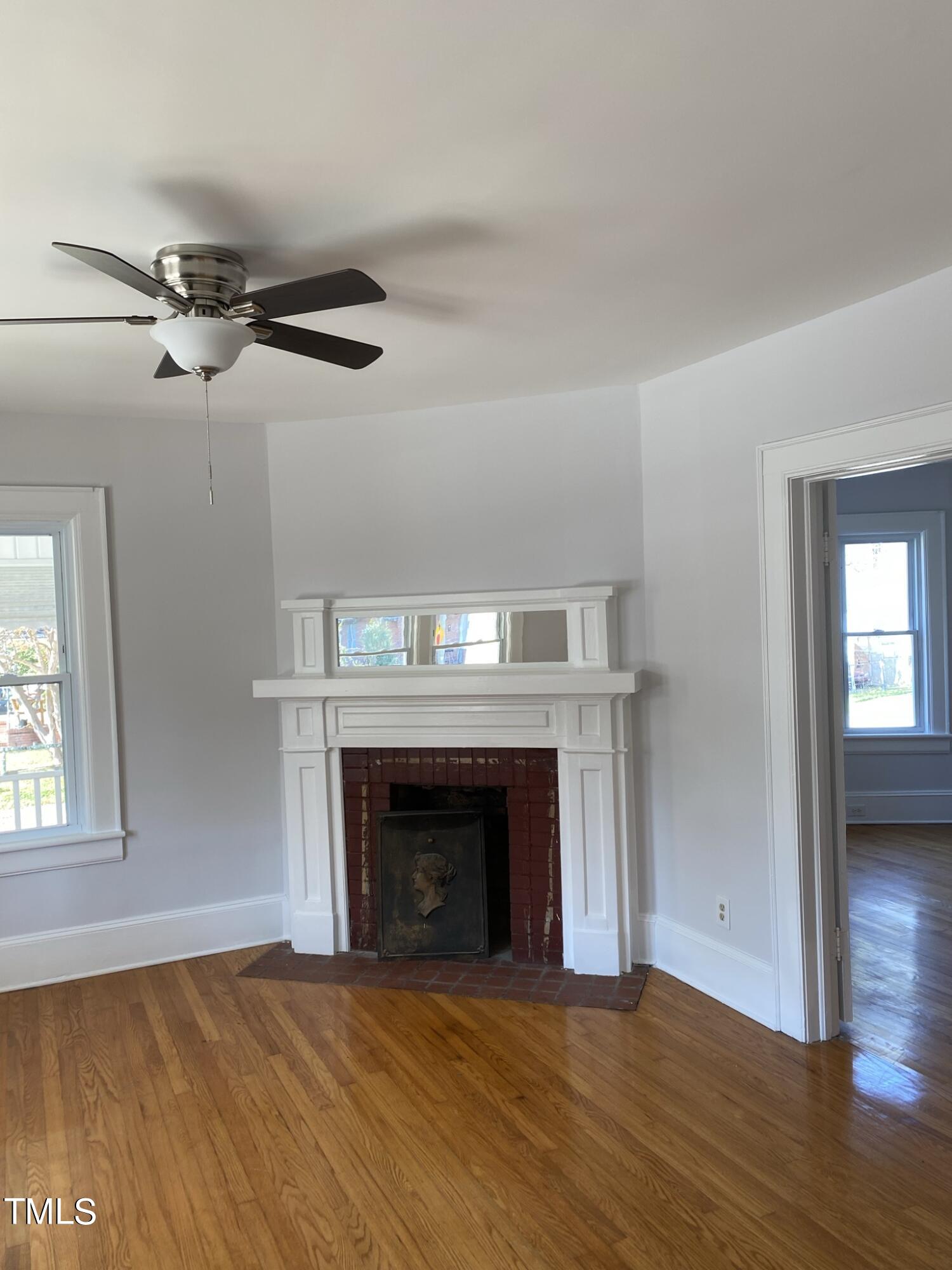 901 East Martin Street Raleigh, NC 27601 - Photo 8 of 42 a view of empty room with wooden floor fireplace and a window