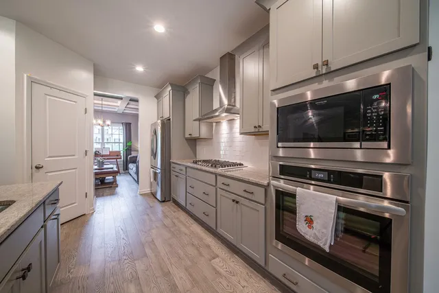 a kitchen with stainless steel appliances and wooden floor