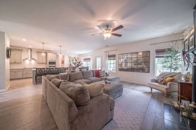 a living room with furniture wooden floor and a large window