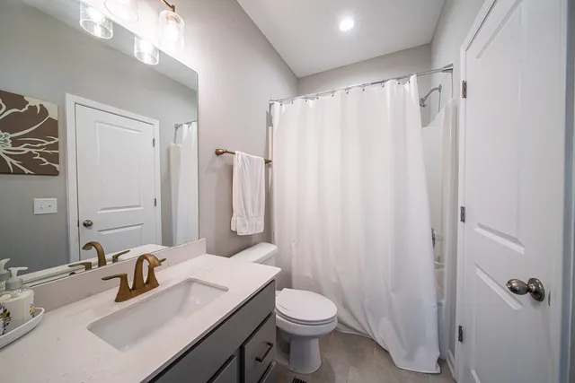 a bathroom with a sink a toilet and shower curtain
