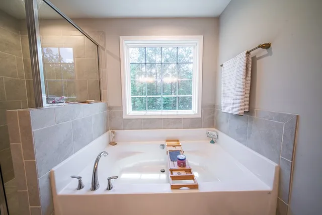 a bath tub sitting in a bathroom next to a window