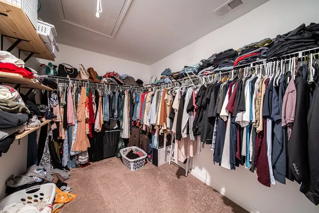 a view of walk in closet with clothes